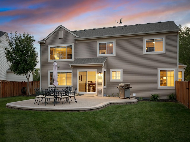 9312 Bristol Ln, Huntley, IL 60142 - back of property at dusk with a fenced backyard, a patio, and roof with shingles