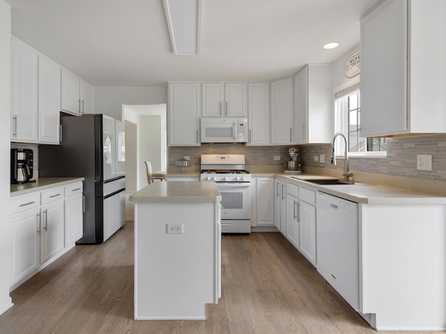 9312 Bristol Ln, Huntley, IL 60142 - kitchen with white appliances, a center island, white cabinetry, light wood-style floors, and backsplash