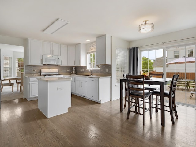 9312 Bristol Ln, Huntley, IL 60142 - kitchen with white appliances, a kitchen island, decorative backsplash, dark wood-type flooring, and light countertops