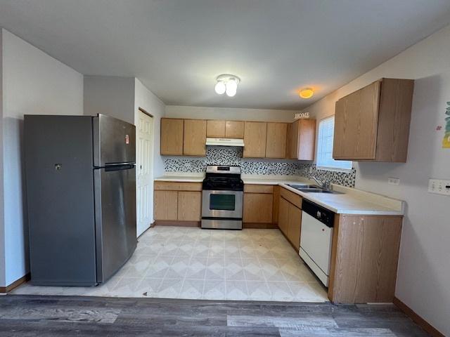 923 E Savannah Dr, Romeoville, IL 60446 - kitchen featuring appliances with stainless steel finishes, light countertops, light flooring, under cabinet range hood, and tasteful backsplash