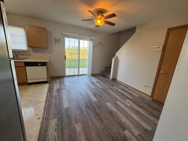 923 E Savannah Dr, Romeoville, IL 60446 - unfurnished living room featuring a ceiling fan, stairway, and light wood-style floors