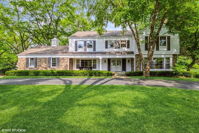 1076 Old Barn Ln, Lake Forest, IL 60045 - view of front of home featuring a front yard, a porch, and a chimney