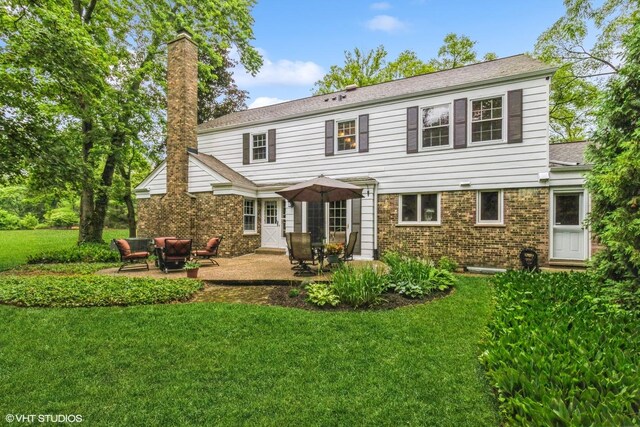 1076 Old Barn Ln, Lake Forest, IL 60045 - rear view of house featuring a yard, a patio area, a chimney, and brick siding