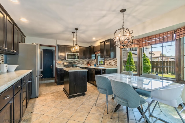 1148 N Anvil Ct, Addison, IL 60101 - kitchen featuring appliances with stainless steel finishes, decorative backsplash, light countertops, a kitchen island, and a chandelier