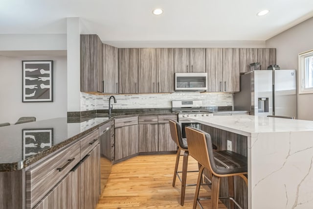 641 S Maple Ave Unit I, Oak Park, IL 60304 - kitchen with appliances with stainless steel finishes, a breakfast bar, tasteful backsplash, light wood-type flooring, and recessed lighting