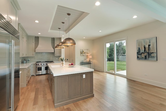 1947 Summerton Pl, Northbrook, IL 60062 - kitchen with premium appliances, custom exhaust hood, light countertops, light wood-style floors, and decorative backsplash