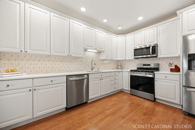 1500 S Ardmore Ave Unit 612, Villa Park, IL 60181 - kitchen with appliances with stainless steel finishes, light countertops, light wood finished floors, white cabinetry, and backsplash
