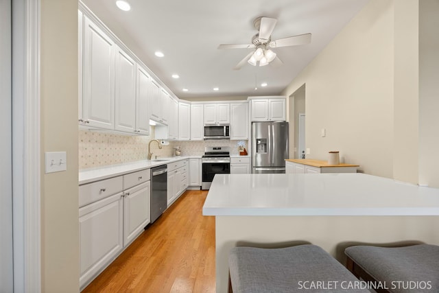 1500 S Ardmore Ave Unit 612, Villa Park, IL 60181 - kitchen featuring stainless steel appliances, white cabinets, light countertops, ceiling fan, and light wood finished floors