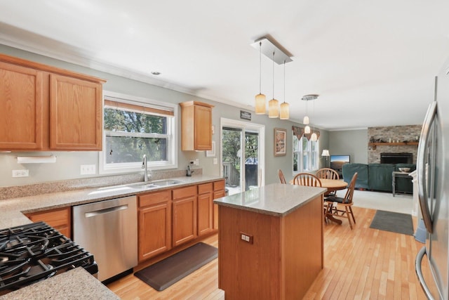 305 Buckingham Dr, Algonquin, IL 60102 - kitchen featuring appliances with stainless steel finishes, a kitchen island, light wood-type flooring, open floor plan, and a stone fireplace