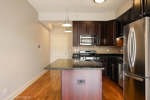 1670 Mill St Unit 508, Des Plaines, IL 60016 - kitchen featuring appliances with stainless steel finishes, backsplash, wood finished floors, decorative light fixtures, and dark stone counters