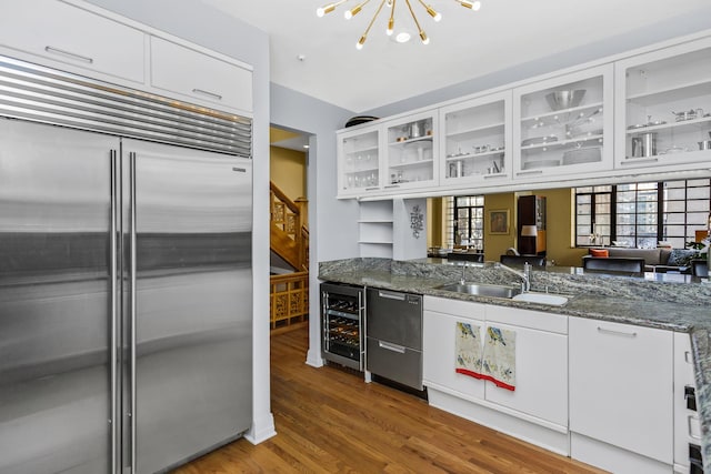 77 E Division St Unit 3, Chicago, IL 60610 - kitchen featuring built in fridge, beverage cooler, a chandelier, dishwashing machine, and white cabinets