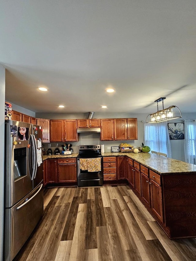 121 N Governor St, Sycamore, IL 60178 - kitchen featuring appliances with stainless steel finishes, a peninsula, dark wood-style flooring, under cabinet range hood, and light stone countertops