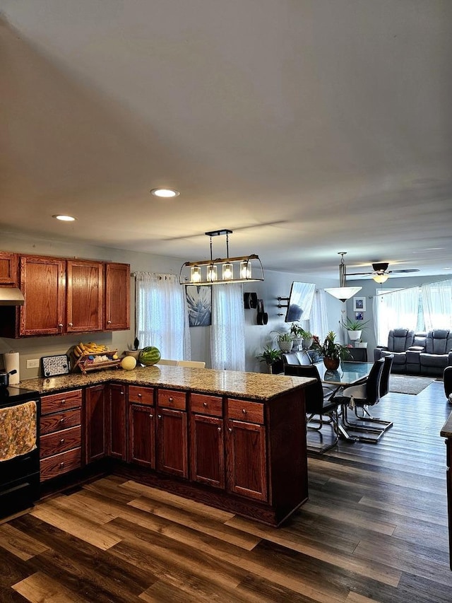 121 N Governor St, Sycamore, IL 60178 - kitchen with black electric range oven, a peninsula, dark wood-style floors, exhaust hood, and open floor plan