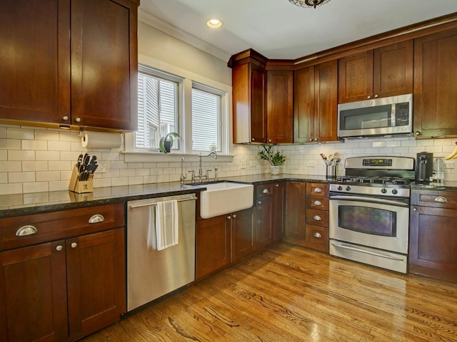 415 N Taylor Ave, Oak Park, IL 60302 - kitchen with stainless steel appliances, light wood-style floors, dark stone countertops, tasteful backsplash, and recessed lighting