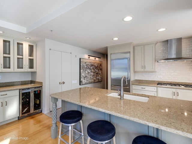 240 E Illinois St Unit 1002, Chicago, IL 60611 - kitchen with wall chimney range hood, wine cooler, stainless steel appliances, a breakfast bar, and light stone counters