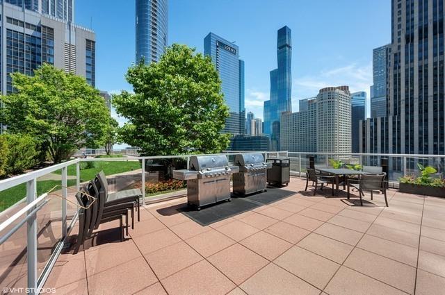 240 E Illinois St Unit 1002, Chicago, IL 60611 - view of patio featuring a view of skyline, a grill, and outdoor dining area