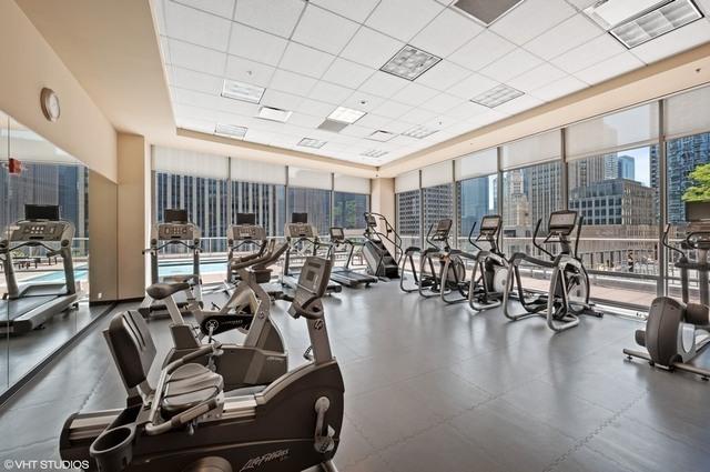 240 E Illinois St Unit 1002, Chicago, IL 60611 - gym featuring a wall of windows, a paneled ceiling, and a city view
