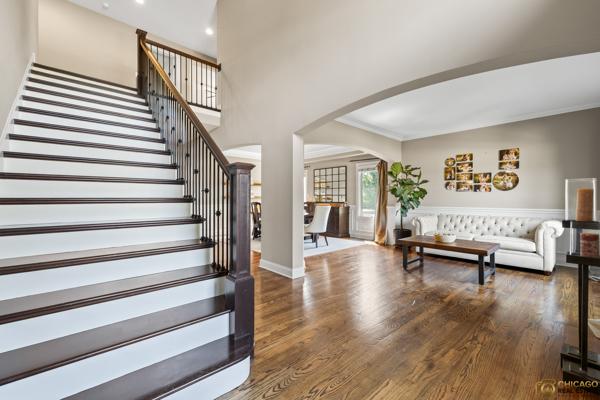 13119 Kinsale Ct, Lemont, IL 60439 - living room featuring arched walkways, wood finished floors, stairway, and recessed lighting