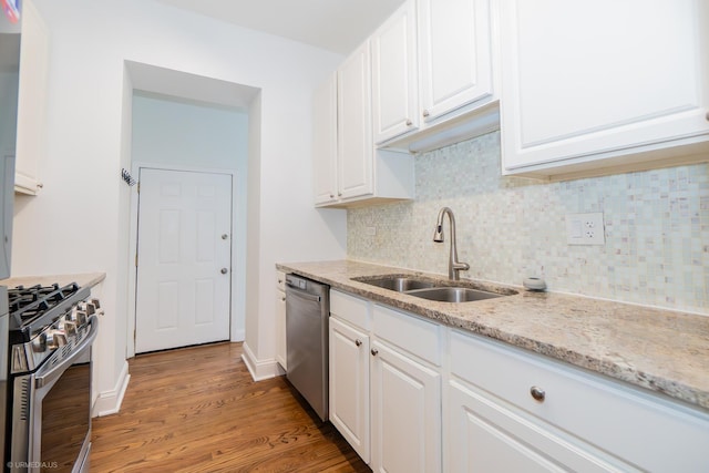 4536 N Sheridan Rd Unit 104, Chicago, IL 60640 - kitchen with stainless steel appliances, white cabinetry, decorative backsplash, light stone counters, and light wood-style flooring