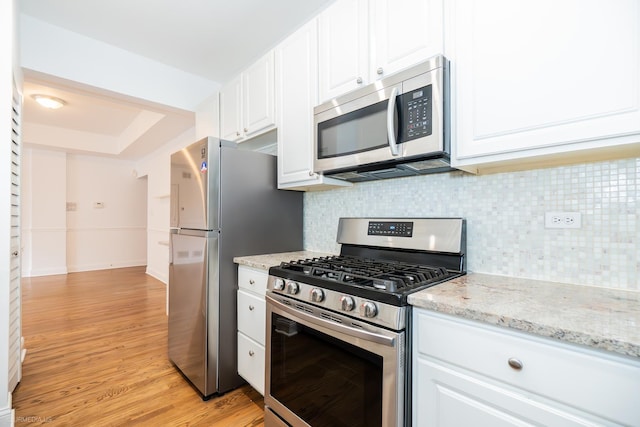 4536 N Sheridan Rd Unit 104, Chicago, IL 60640 - kitchen featuring stainless steel appliances, light wood finished floors, tasteful backsplash, and white cabinetry