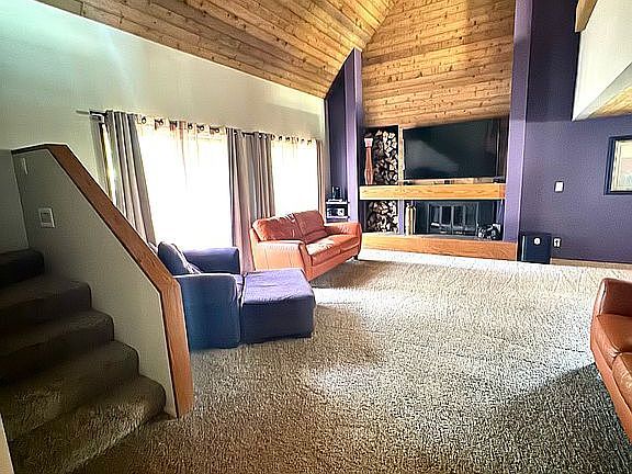 2303 Sumac Ct, Champaign, IL 61821 - carpeted living area featuring stairs, wooden ceiling, and high vaulted ceiling
