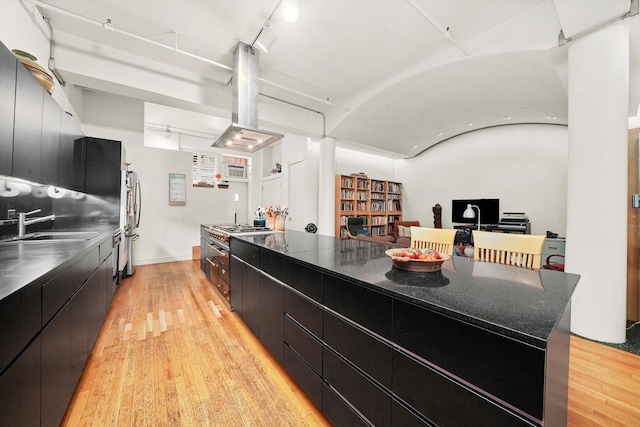 727 S Dearborn St Unit 311, Chicago, IL 60605 - kitchen with island range hood, dark cabinetry, modern cabinets, light wood-style floors, and refrigerator