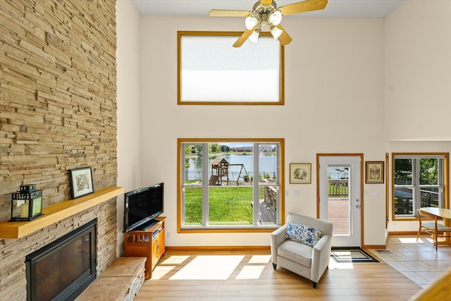 3220 Weeping Cherry Dr, Champaign, IL 61822 - living room with a towering ceiling, light wood-type flooring, a stone fireplace, and a ceiling fan