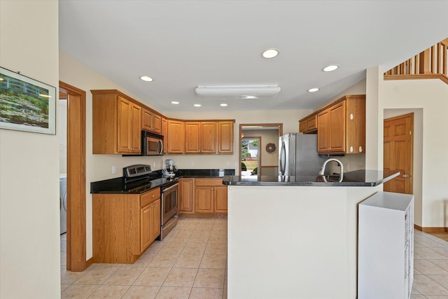 3220 Weeping Cherry Dr, Champaign, IL 61822 - kitchen with appliances with stainless steel finishes, light tile patterned flooring, a peninsula, dark countertops, and recessed lighting