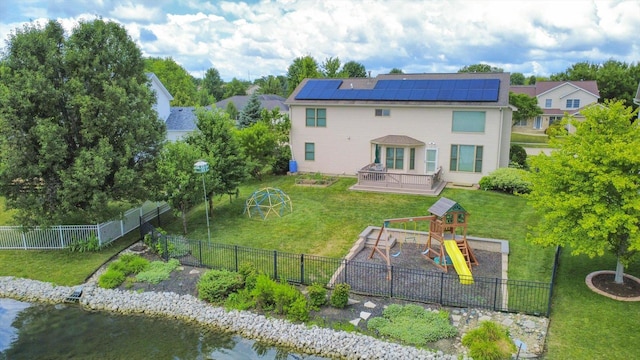 3220 Weeping Cherry Dr, Champaign, IL 61822 - rear view of house featuring a playground, solar panels, a wooden deck, and a fenced backyard