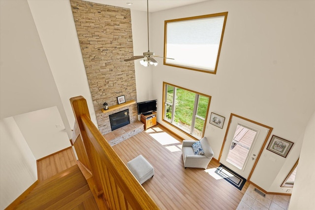 3220 Weeping Cherry Dr, Champaign, IL 61822 - living room featuring a fireplace, a towering ceiling, light wood-type flooring, and ceiling fan