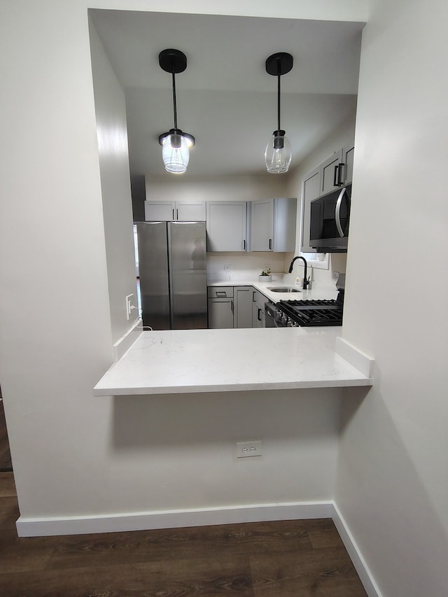1623 S 58th Ct, Cicero, IL 60804 - kitchen with appliances with stainless steel finishes, gray cabinetry, decorative light fixtures, dark wood-style floors, and a peninsula