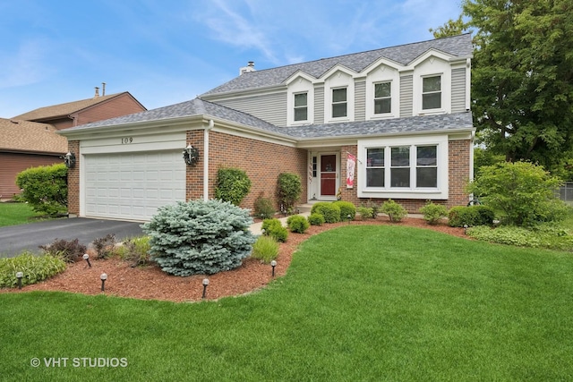 109 N Wilke Rd, Palatine, IL 60074 - traditional-style home with brick siding, a garage, a front yard, asphalt driveway, and a shingled roof