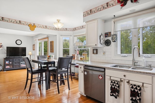 109 N Wilke Rd, Palatine, IL 60074 - kitchen with stainless steel dishwasher, white cabinets, light wood-style floors, backsplash, and open floor plan