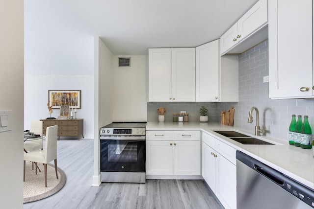 1636 N Wells St Unit 3007, Chicago, IL 60614 - kitchen featuring stainless steel appliances, light wood-style flooring, decorative backsplash, and white cabinets