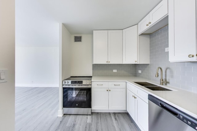 1636 N Wells St Unit 3007, Chicago, IL 60614 - kitchen with stainless steel appliances, light wood-style floors, decorative backsplash, and white cabinets
