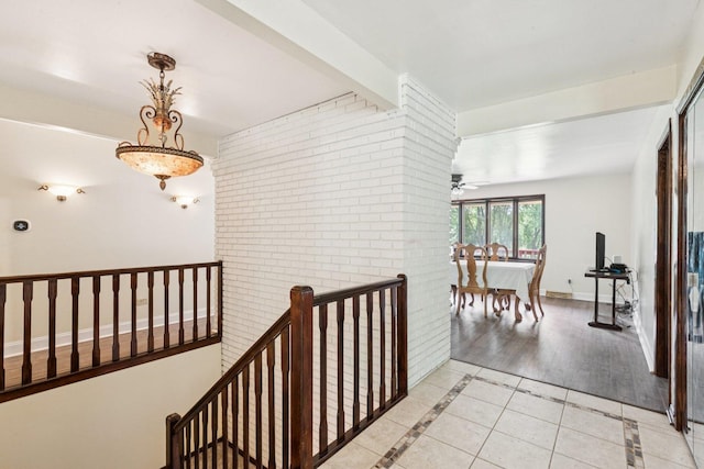 13115 Maple Rd, Mokena, IL 60448 - corridor with an upstairs landing, light tile patterned floors, inlaid floor details, and brick wall