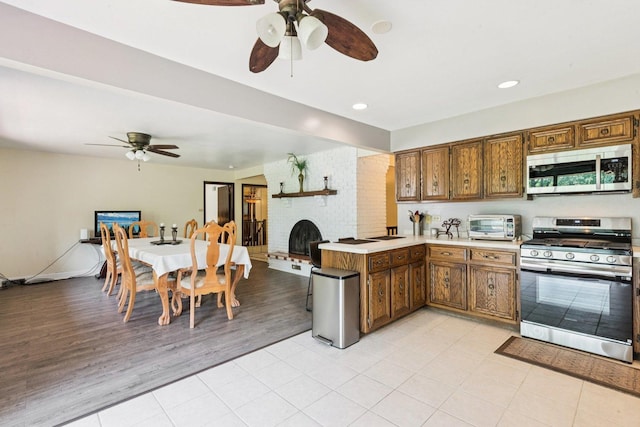 13115 Maple Rd, Mokena, IL 60448 - kitchen featuring appliances with stainless steel finishes, a ceiling fan, a peninsula, light countertops, and recessed lighting