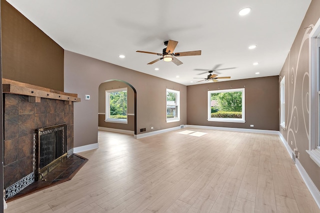 2125 Collett Ln, Flossmoor, IL 60422 - unfurnished living room featuring ceiling fan, a tile fireplace, light wood-style floors, arched walkways, and recessed lighting