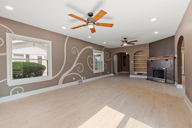 2125 Collett Ln, Flossmoor, IL 60422 - unfurnished living room featuring arched walkways, ceiling fan, recessed lighting, light wood-type flooring, and a tiled fireplace