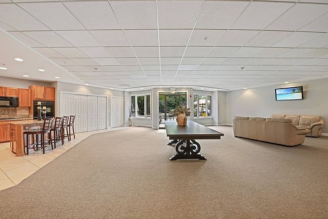 1 Renaissance Pl Unit 1212, Palatine, IL 60067 - rec room with light carpet, light tile patterned floors, and a paneled ceiling