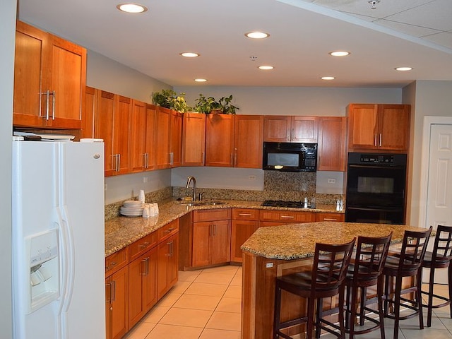 1 Renaissance Pl Unit 1212, Palatine, IL 60067 - kitchen featuring black appliances, light tile patterned flooring, recessed lighting, a kitchen bar, and light stone counters
