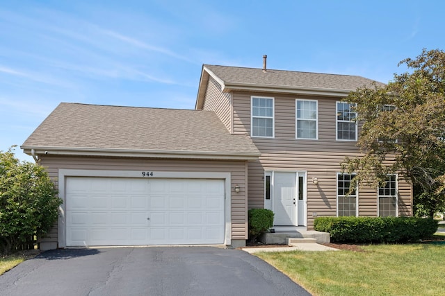 944 W Briarcliff Rd, Bolingbrook, IL 60440 - colonial house with asphalt driveway, an attached garage, a front lawn, and roof with shingles