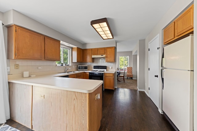 944 W Briarcliff Rd, Bolingbrook, IL 60440 - kitchen with white appliances, dark wood finished floors, a peninsula, light countertops, and decorative backsplash