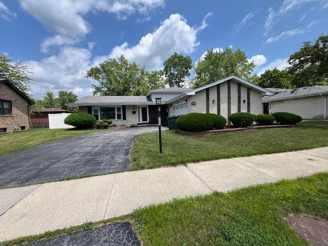 824 E 193rd Pl, Glenwood, IL 60425 - view of front facade featuring asphalt driveway, an attached garage, and a front lawn
