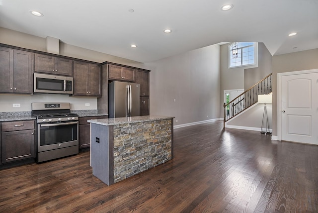 14903 S Preserve Dr, Lockport, IL 60441 - kitchen with appliances with stainless steel finishes, dark brown cabinets, light stone counters, dark wood-type flooring, and a kitchen island