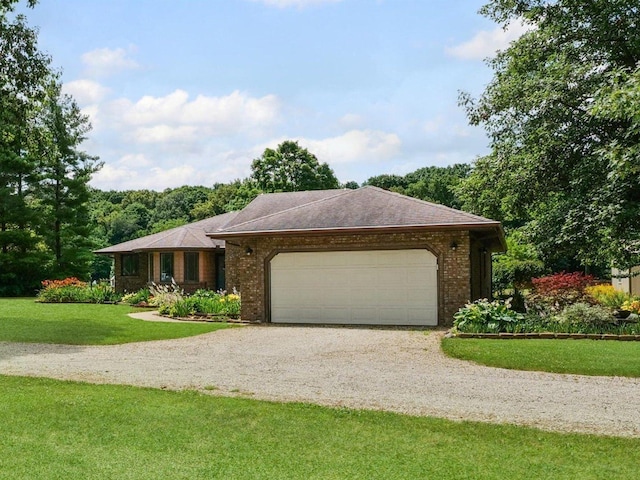 2911 E Oaks Rd N, Urbana, IL 61802 - single story home with gravel driveway, an attached garage, a front yard, and brick siding