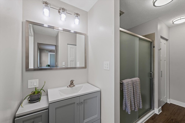 2911 E Oaks Rd N, Urbana, IL 61802 - bathroom with vanity, a shower stall, wood finished floors, and a textured ceiling