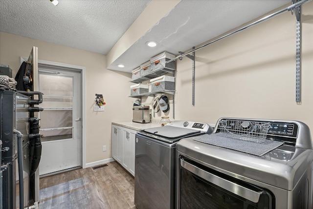 2911 E Oaks Rd N, Urbana, IL 61802 - washroom with cabinet space, light wood finished floors, independent washer and dryer, recessed lighting, and a textured ceiling