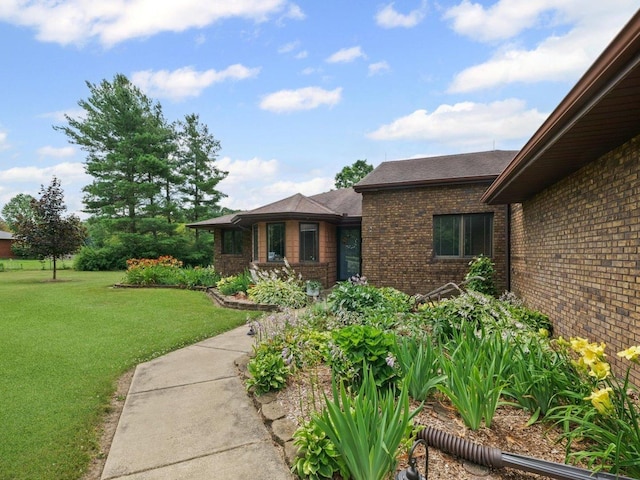 2911 E Oaks Rd N, Urbana, IL 61802 - doorway to property featuring brick siding, a yard, and roof with shingles