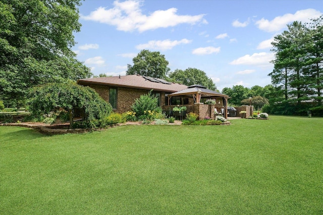 2911 E Oaks Rd N, Urbana, IL 61802 - back of house with a gazebo, roof mounted solar panels, a lawn, and brick siding